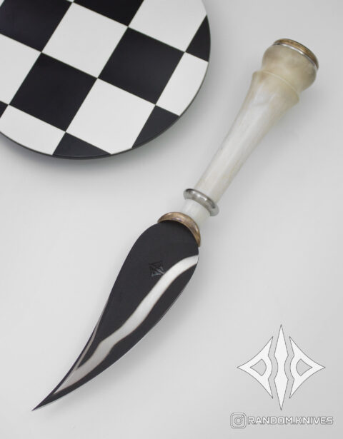 Cuchillo conceptual Alfil apoyado sobre un tablero de ajedrez